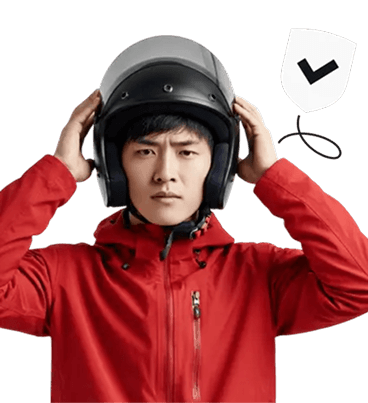 A man in a red jacket putting on a helmet