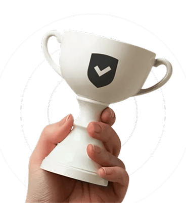 A hand holding a white chalice with a checkmarked shield on it
