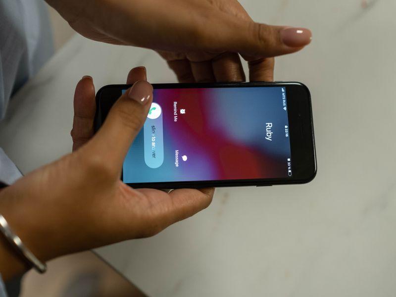 A close-up of a phone screen showing an incoming call labelled "CEO," reflected in someone's glasses in a dim office.