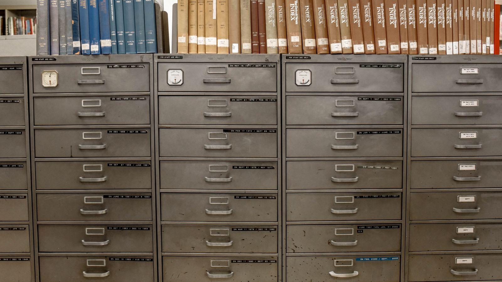 A row of filing cabinets dissolving into pixels, each drawer labelled with a different people-search site logo silhouette.