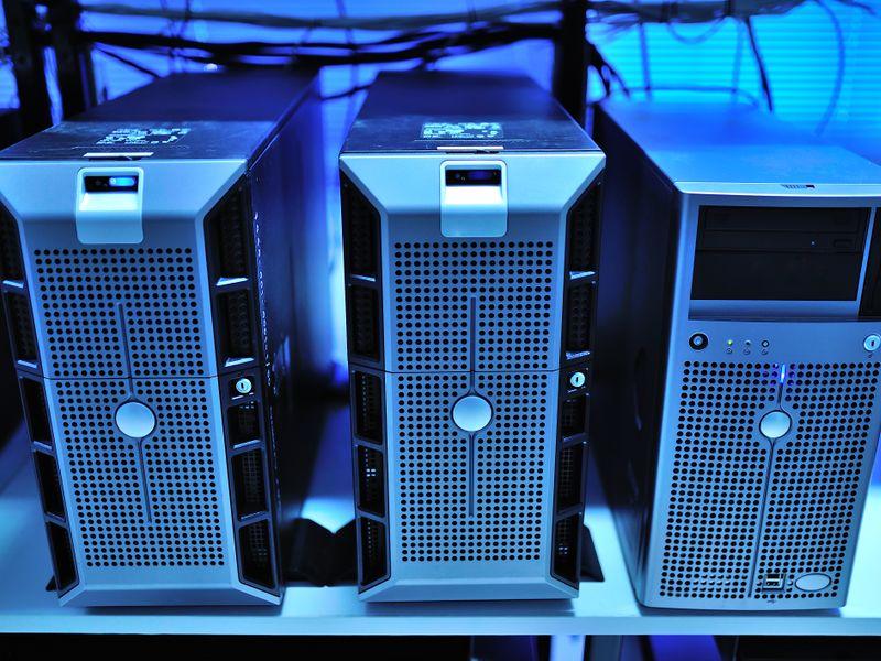 A bare metal server with its lid open, cables visible, no SSDs in the drive bays.