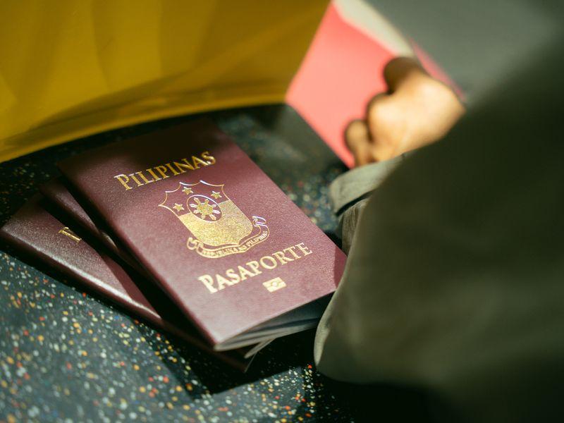 A passport, a YubiKey, and a phone on a wooden surface, laid out for packing.
